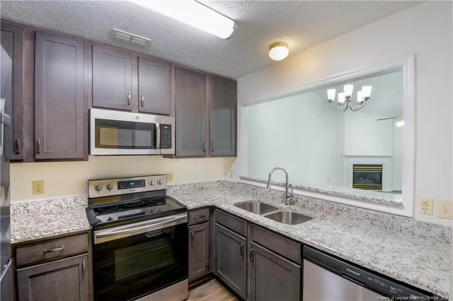 a kitchen with granite countertop stainless steel appliances and wooden cabinets