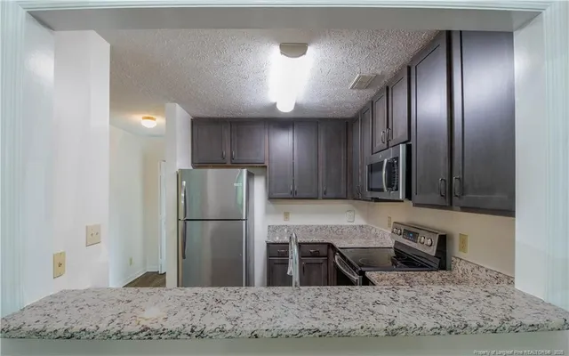 a view of a livingroom with a chandelier fireplace and wooden floor