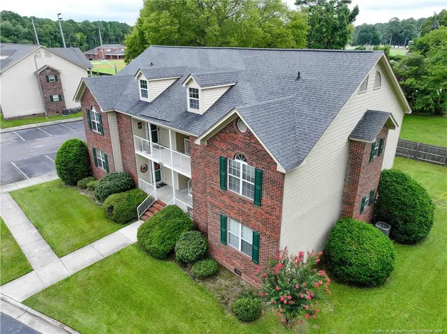 a aerial view of a house with yard and green space
