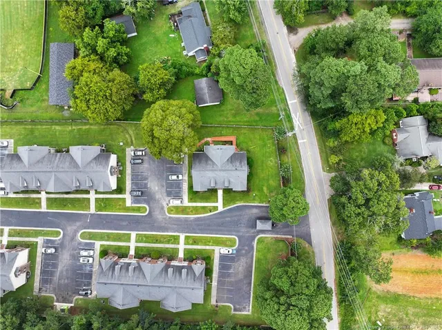 an aerial view of a multi story residential apartment building with a yard