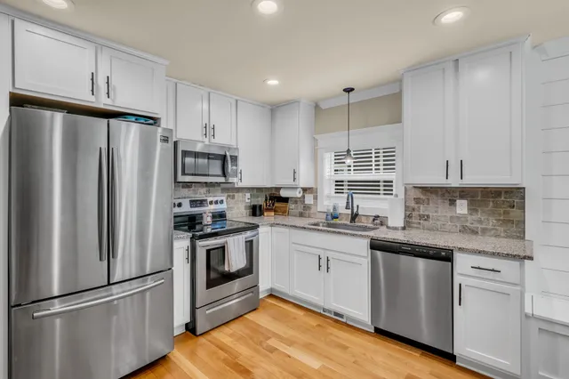 a kitchen with granite countertop stainless steel appliances and wooden cabinets