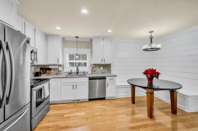 a kitchen with stainless steel appliances kitchen island granite countertop a sink refrigerator and cabinets