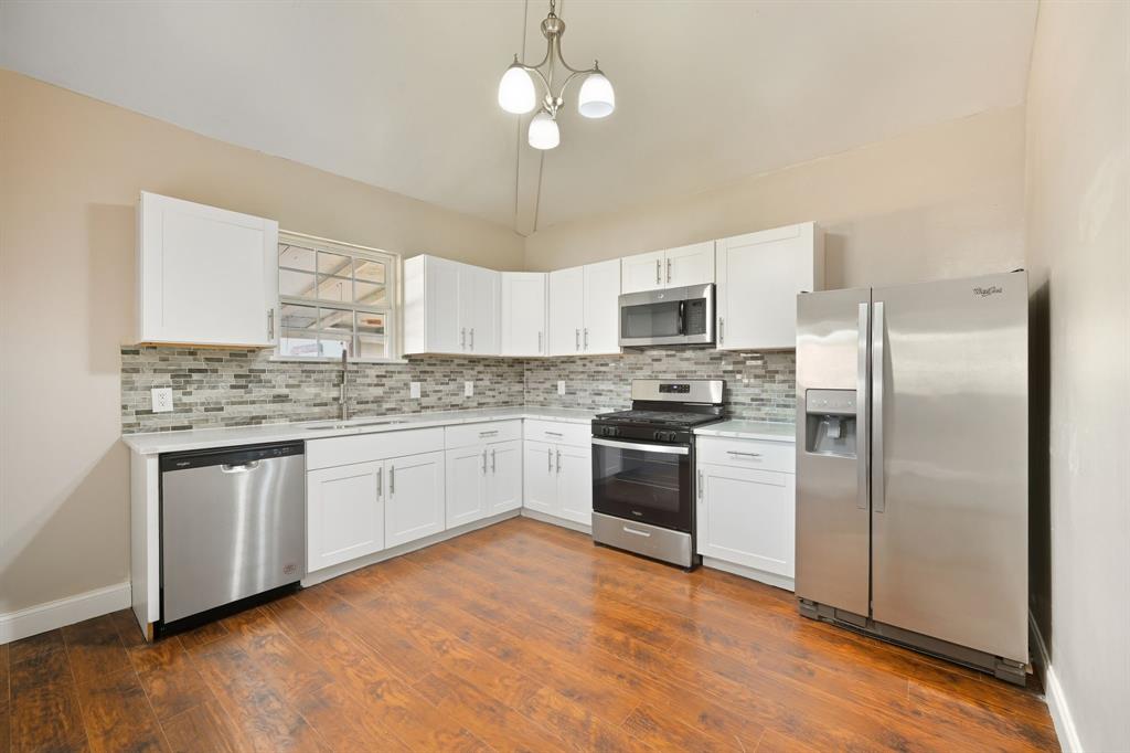 a kitchen with a refrigerator sink and cabinets