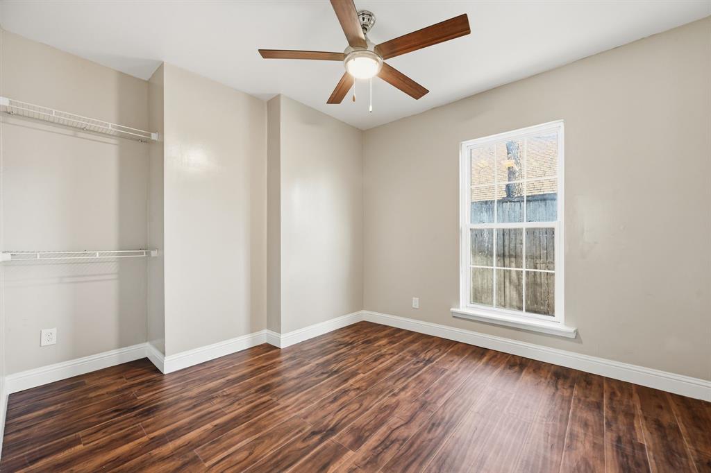 4219 Frank Street Dallas, TX 75210 - Photo 11 of 23 an empty room with wooden floor chandelier fan and windows