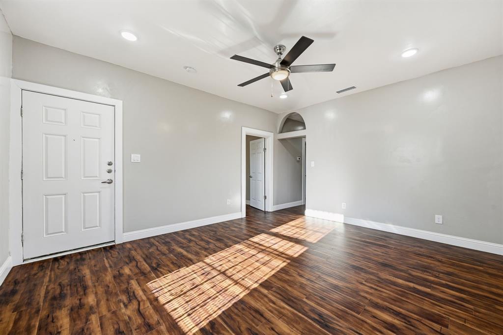 4219 Frank Street Dallas, TX 75210 - Photo 15 of 23 a view of an empty room with wooden floor and a ceiling fan