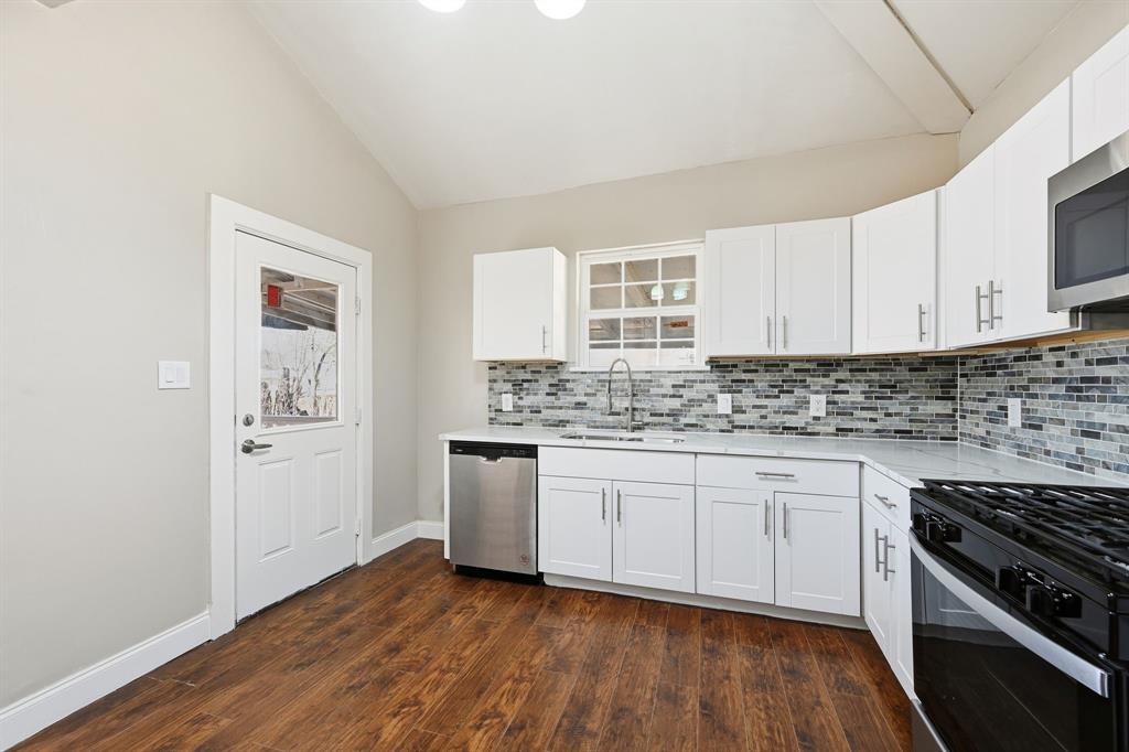 4219 Frank Street Dallas, TX 75210 - Photo 3 of 23 a kitchen with granite countertop a stove a sink and a refrigerator