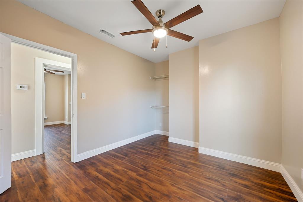 4219 Frank Street Dallas, TX 75210 - Photo 8 of 23 an empty room with wooden floor and a ceiling fan