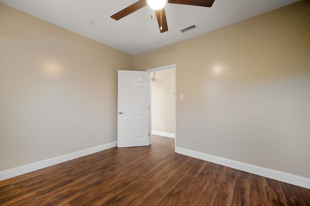 4219 Frank Street Dallas, TX 75210 - Photo 9 of 23 an empty room with wooden floor and a ceiling fan