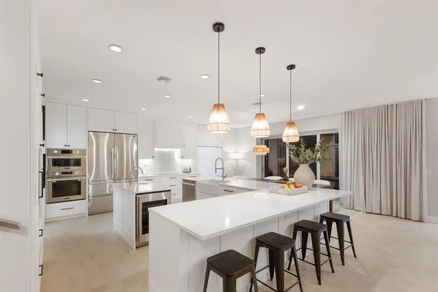 a kitchen with stainless steel appliances a refrigerator sink and white cabinets