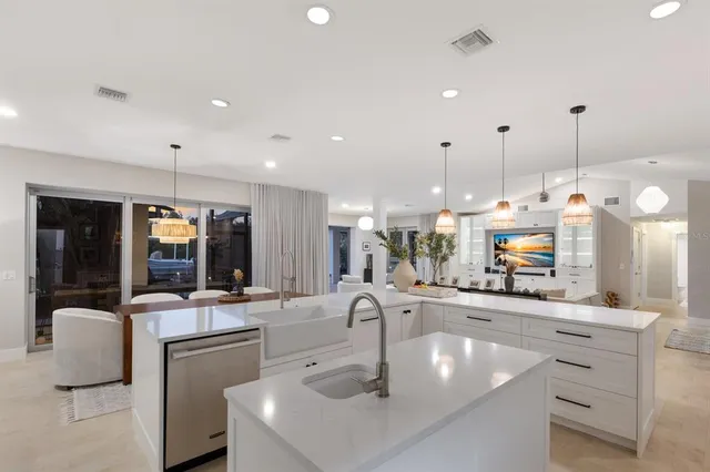 a kitchen with stainless steel appliances granite countertop a stove a sink dishwasher a dining table and chairs with wooden floor