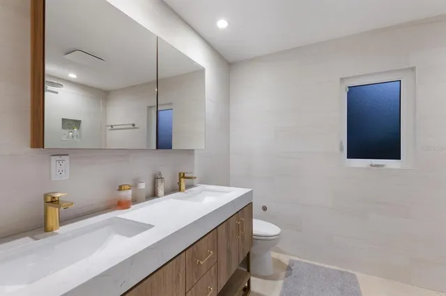 a spacious bedroom with a bed and a flat screen tv