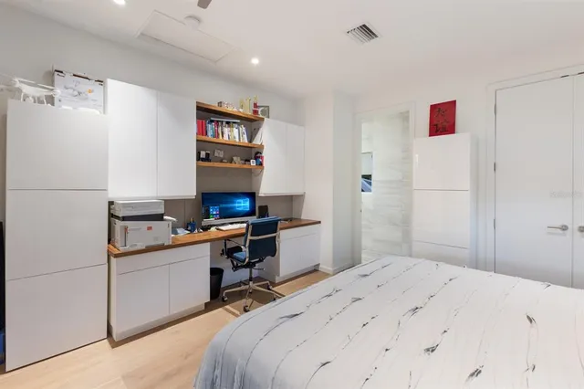 a bedroom with a large bed and a chandelier