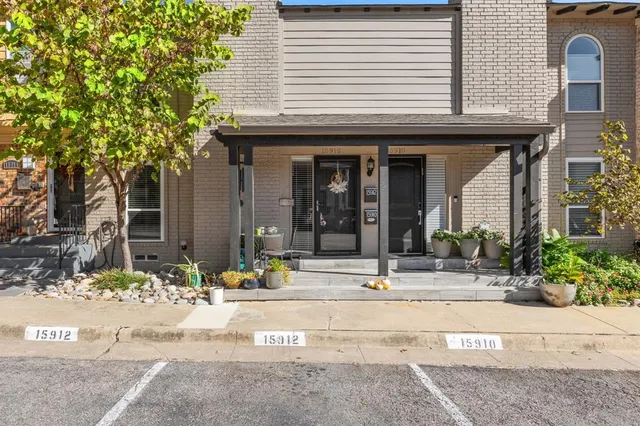 a view of a brick house with potted plants