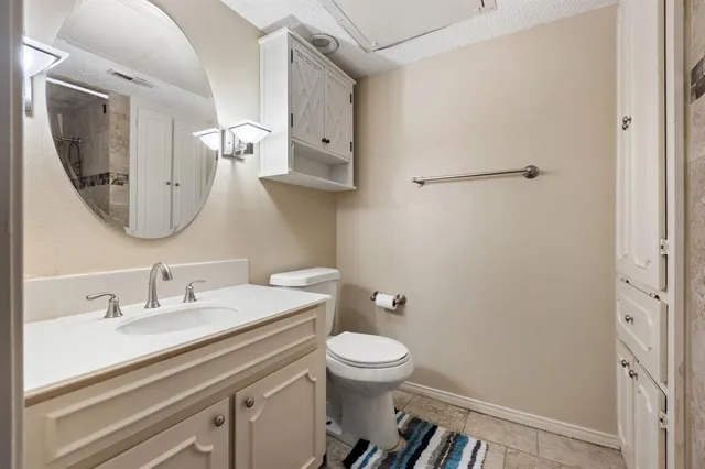 a bathroom with a toilet a sink a mirror and vanity