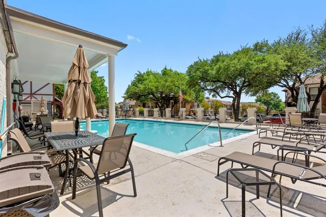 a view of a patio with a table and chairs under an umbrella