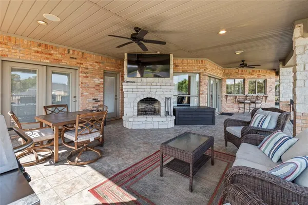 a living room with furniture a flat screen tv and floor to ceiling window
