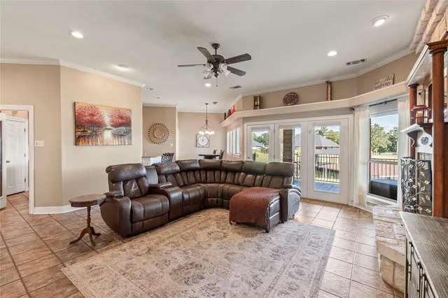 a spacious bedroom with a large bed a large window with table and chairs