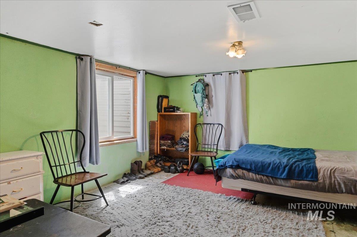 1958 East 1775 South Gooding, ID 83330 - Photo 33 of 49 Recessed ceiling vent, window with wood trim, ceiling-mounted light fixture, light green wall finishes, and white ceiling