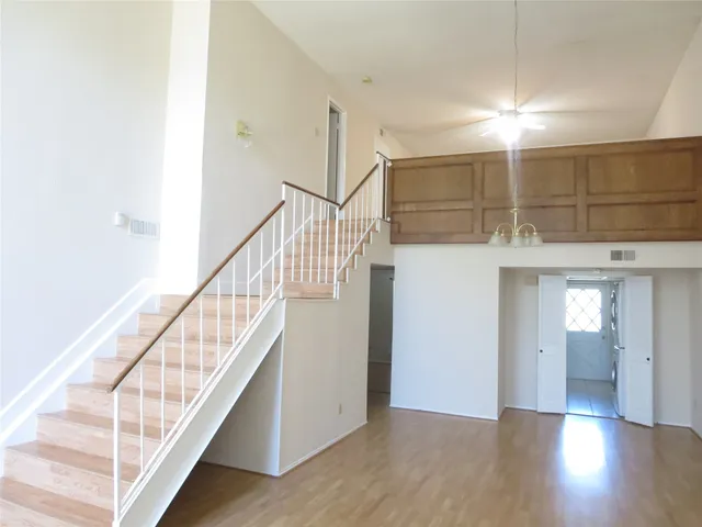 a view of a hallway with wooden floor and entryway