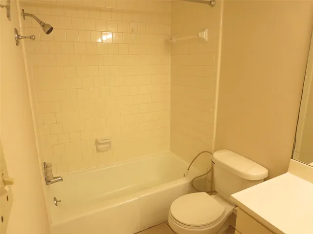 a white toilet sitting next to a bath tub