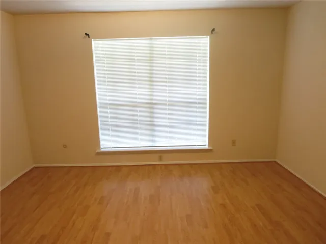 a view of a small space with wooden floor and a window