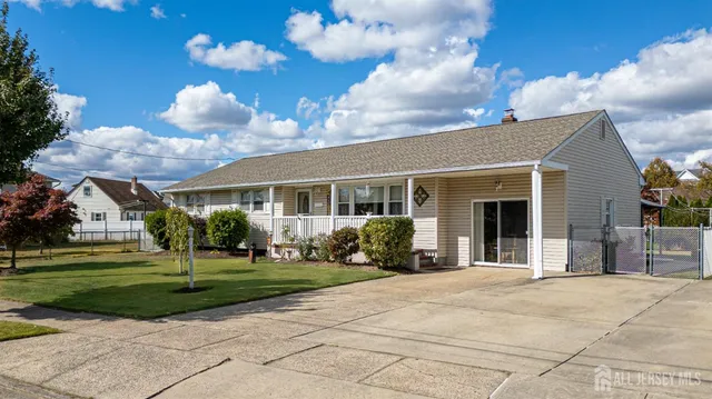 a view of a white house with a big yard and potted plants