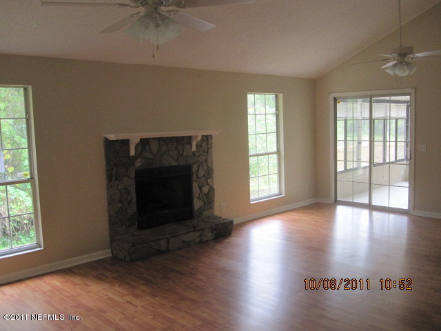 5103 Damascus Road West Jacksonville, FL 32207 - Photo 7 of 23 an empty room with wooden floor fireplace and windows