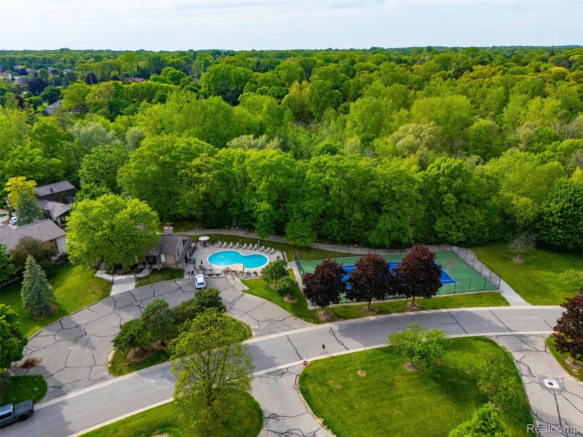 1687 Lodge Pole Lane Rochester, MI 48309 - Photo 46 of 53 Community amenities featuring a swimming pool with surrounding deck, tennis courts, and mature landscaping