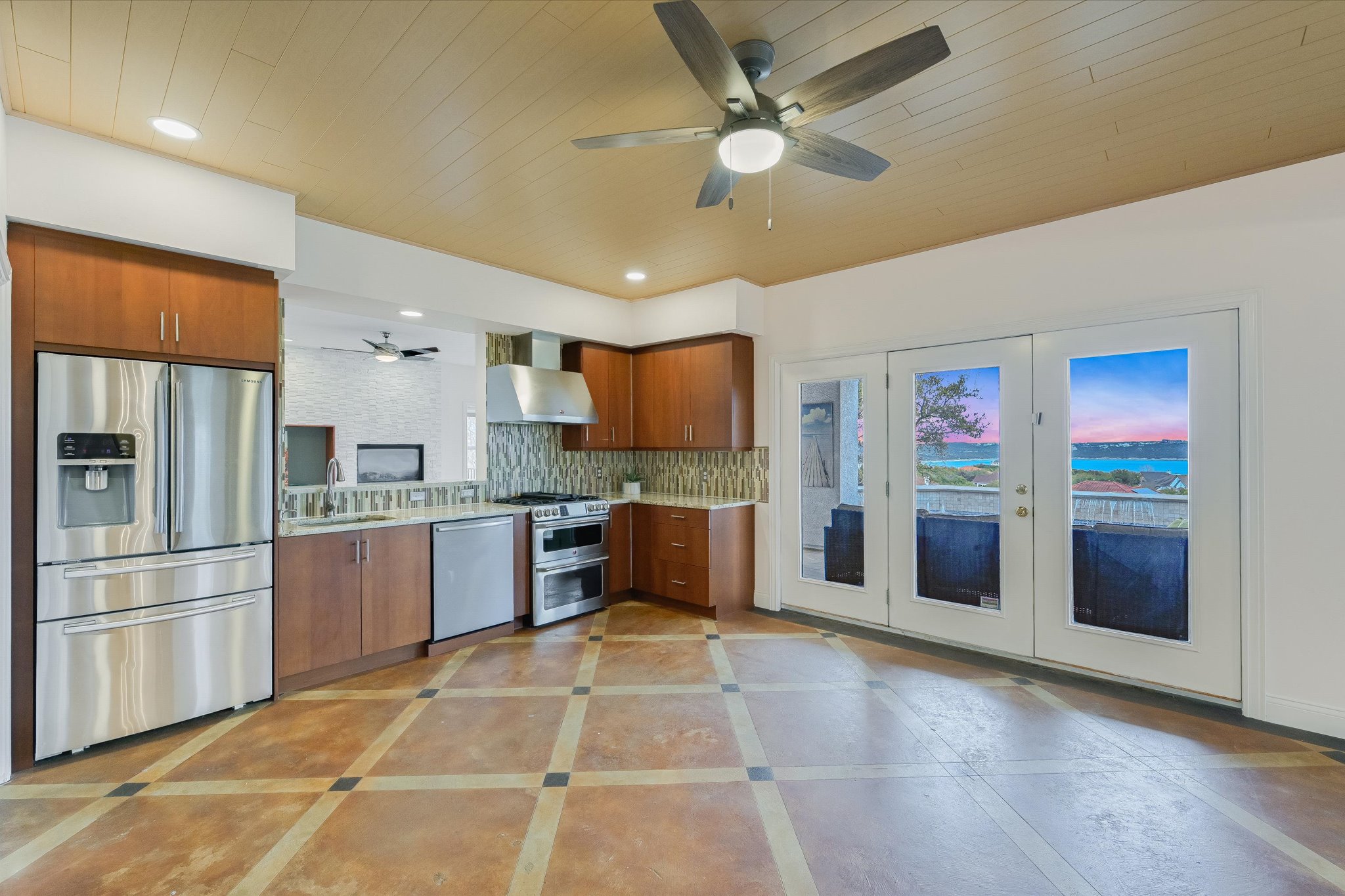 4319 Rum Runner Road Austin, TX 78734 - Photo 31 of 40 Kitchen with a ceiling fan, stainless steel appliances, decorative backsplash, french doors, and wood finish cabinetry