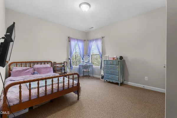 a bedroom with a bed and large windows