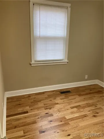 a view of a room with wooden floor and fan