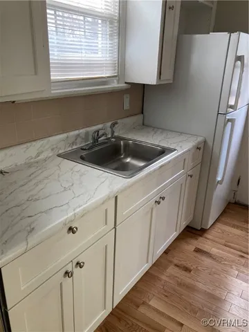 a kitchen with a sink cabinets and a window