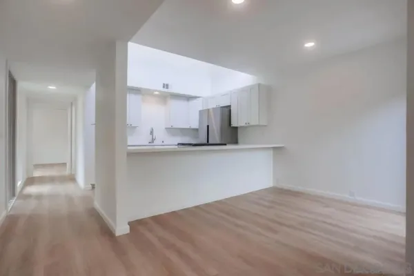 a view of a kitchen with wooden floor and electronic appliances