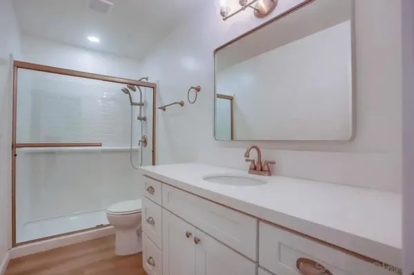 a bathroom with a sink a toilet and shower