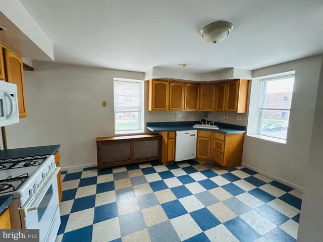 a kitchen with a checkered floor and white cabinets