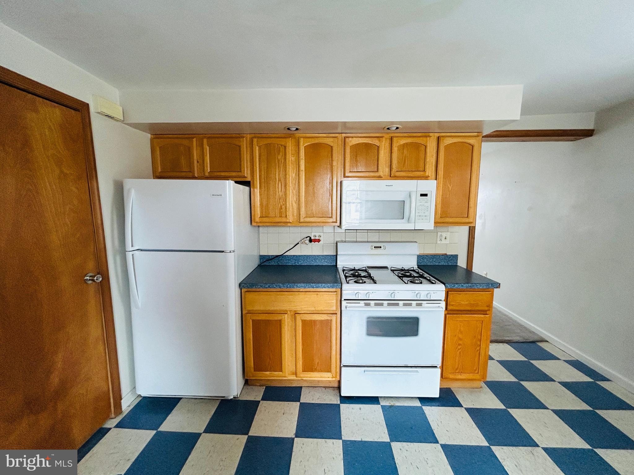 6500 Ridge Avenue, Unit 2 Philadelphia, PA 19128 - Photo 4 of 17 a kitchen with a stove a refrigerator and a stove top oven