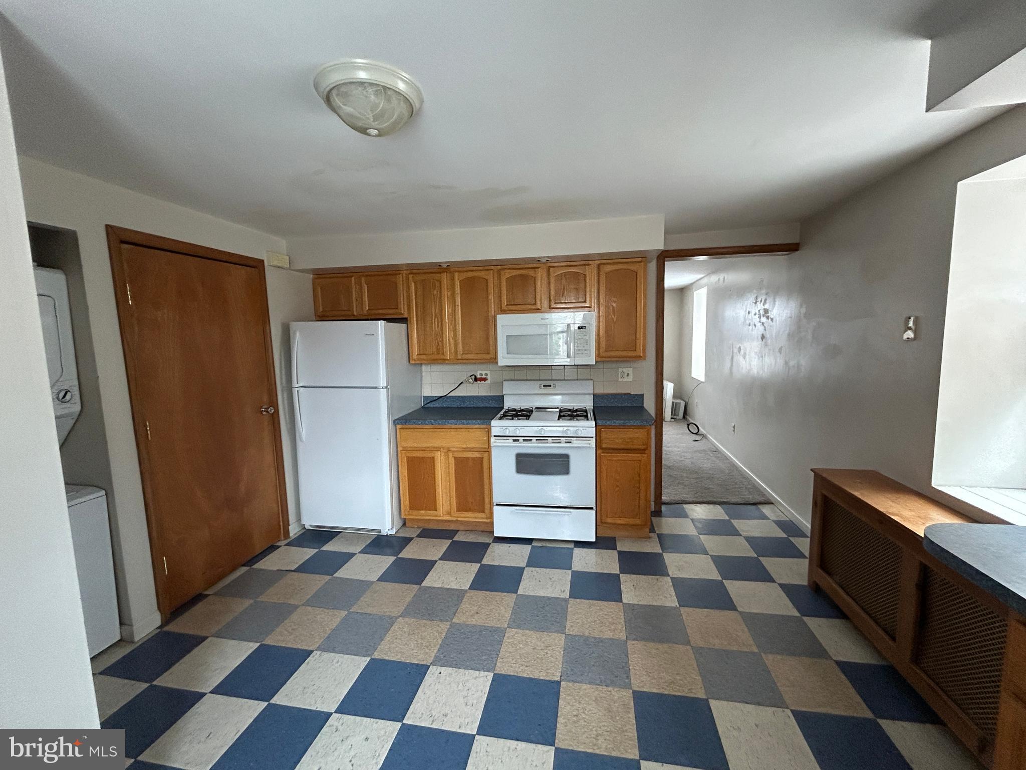 6500 Ridge Avenue, Unit 2 Philadelphia, PA 19128 - Photo 5 of 17 a kitchen with a checkered floor and white cabinets