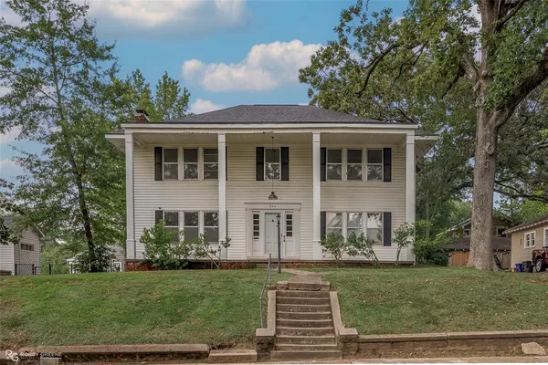 a front view of a house with a garden