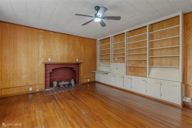 a view of an empty room with a fireplace and a window