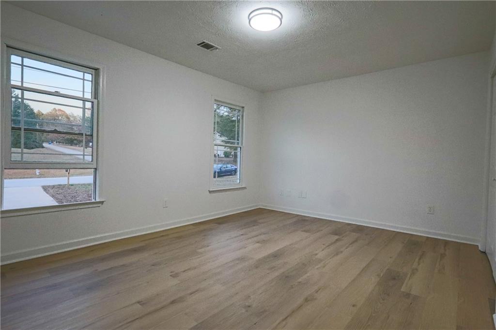 491 Glen Terrace Road Auburn, GA 30011 - Photo 13 of 19 an empty room with wooden floor and windows