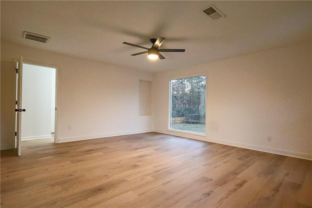 491 Glen Terrace Road Auburn, GA 30011 - Photo 15 of 19 an empty room with wooden floor ceiling fan and window