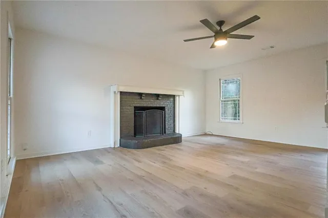 an empty room with windows and fireplace