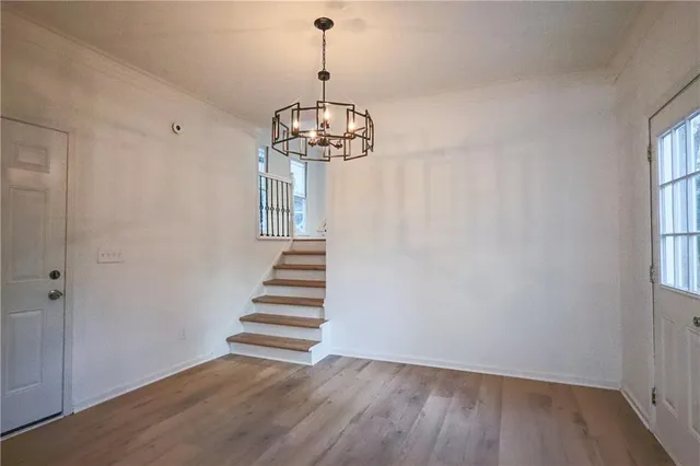 a view of empty room with wooden floor and window
