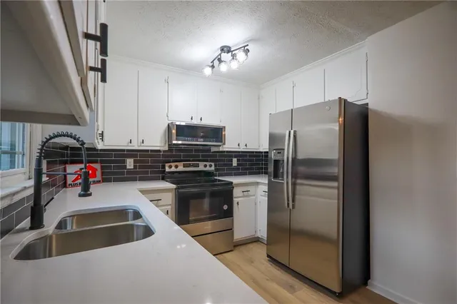 a kitchen with refrigerator a stove a sink and a microwave