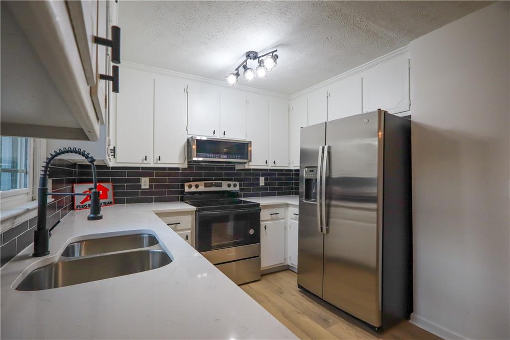 491 Glen Terrace Road Auburn, GA 30011 - Photo 7 of 19 a kitchen with refrigerator a stove a sink and a microwave
