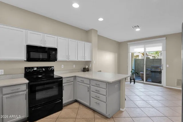 a kitchen with sink a microwave and cabinets