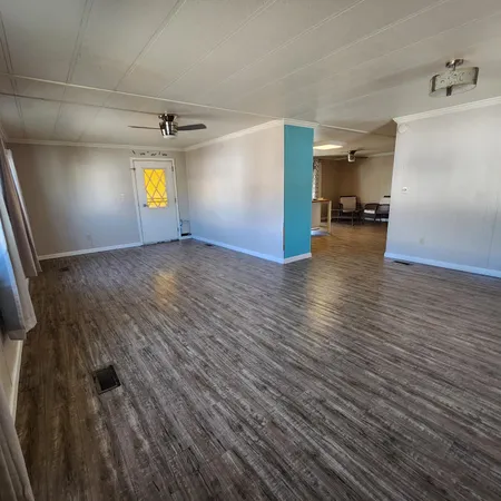 a view of empty room with window and wooden floor