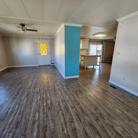 a view of empty room with wooden floor and window
