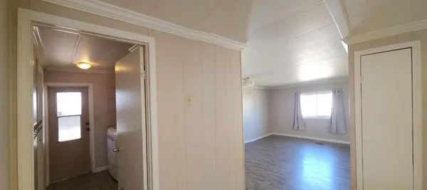 a view of a hallway with wooden floor and closet