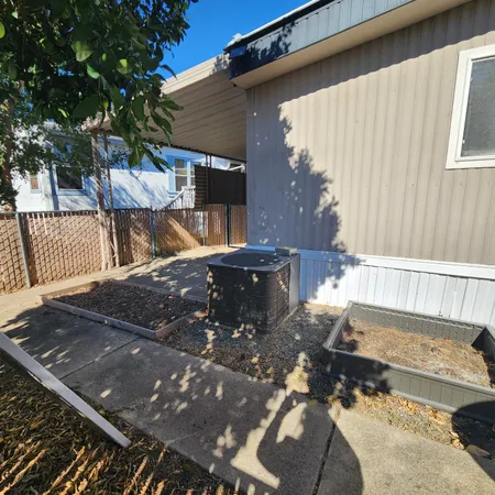 a view of a backyard with table and chairs with wooden fence and plants